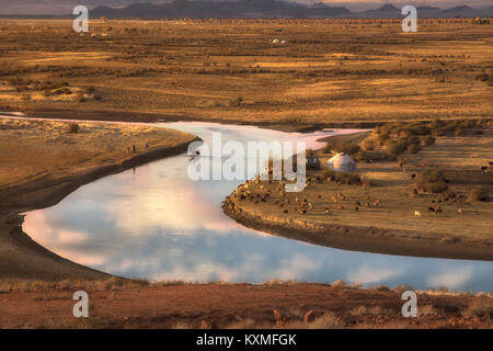 Sunset horse crossing river Mongolia landscape plains grasslands steppes goats herd ger golden hour Stock Photo