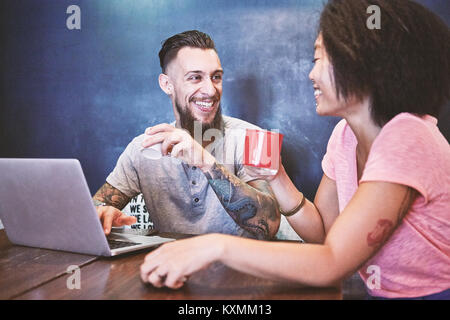 Multi ethnic hipster couple in cafe using laptop,Shanghai French Concession,Shanghai,China Stock Photo