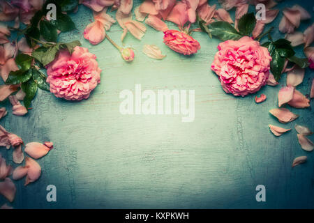 Pink roses background on retro toned shabby chic wood, top view, retro toned, floral border Stock Photo