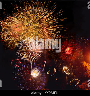 Colorful fire flowers of festive fireworks  various colors and shapes at night sky Stock Photo