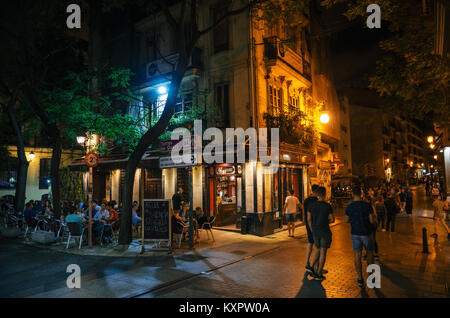 Valencia, Spain - June 2, 2016: Tourists and locals walk in narrow streets with cafe and restaurant at night. Stock Photo