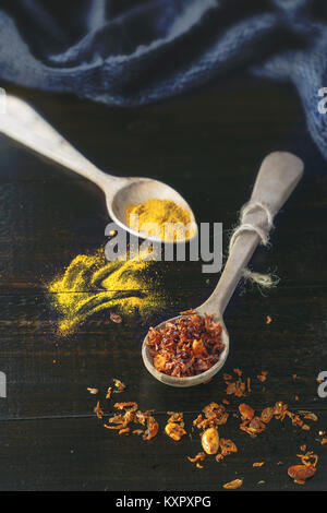 Wooden spoons with turmeric and Baharat Spice Blend (Middle Eastern spice mixture)  on old rustic wooden background. Selective focus. Stock Photo