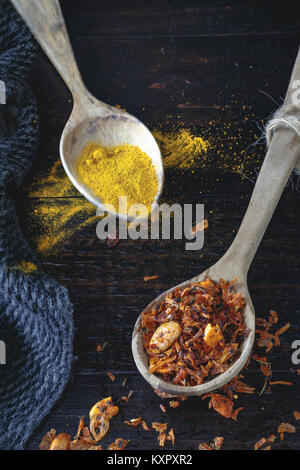 Wooden spoons with turmeric and Baharat Spice Blend (Middle Eastern spice mixture)  on old rustic wooden background. Selective focus. Stock Photo