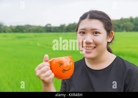 Asian Teen fat women hold mug with green nature background fresh nature healthy drink concept Stock Photo