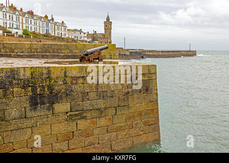 An historic cannon guards the entrance to the granite harbour at Porthleven on the south coast of Cornwall, England, UK Stock Photo