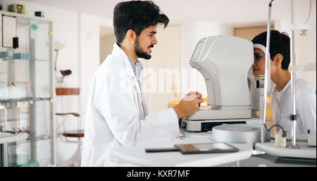 Attentive optometrist examining female patient on slit lamp Stock Photo