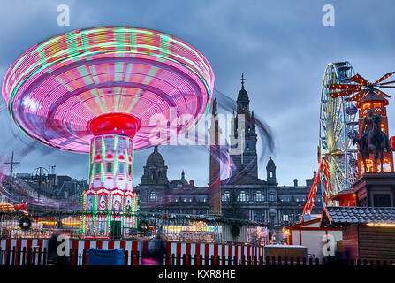 Christmas fair with carousels spinning on George Square in Glasgow city, Scotland. Stock Photo