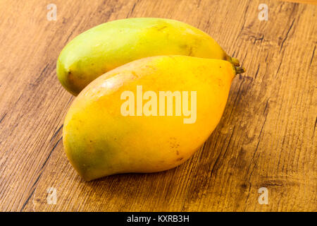 Sweet mango fruit over the wooden background Stock Photo