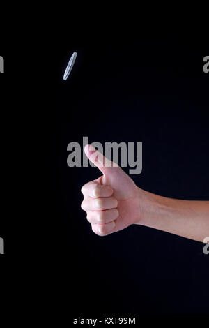 Concept image of flipping a coin up in the air. Stock Photo