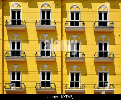 Dramatic shadows on the yellow facade of a classical town house in Singapore Stock Photo