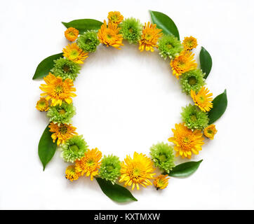 Flower composition round frame wreath made of various yellow and green flowers on white background.  Flat lay, top view Stock Photo