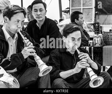 Men playing traditional music instrument in Sapa market, Vietnam Stock Photo