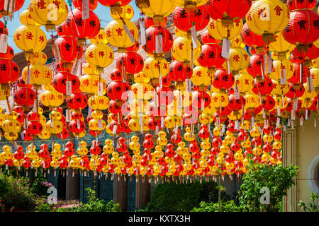 Red and yellow Chinese paper lanterns in abundance, hanging on strings at the garden of the Kek Lok Si Temple in Penang during Chinese New Year. Stock Photo