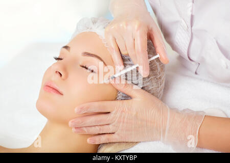 A woman receives an inejection on her face. Stock Photo