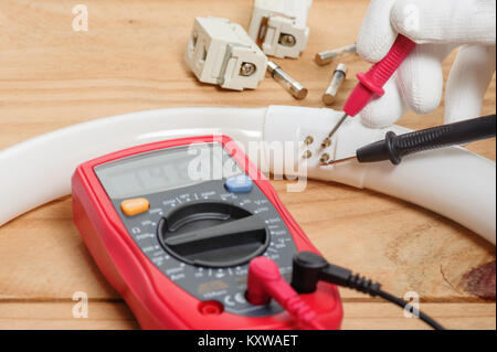 electrician using the digital multimeter in workshop Stock Photo