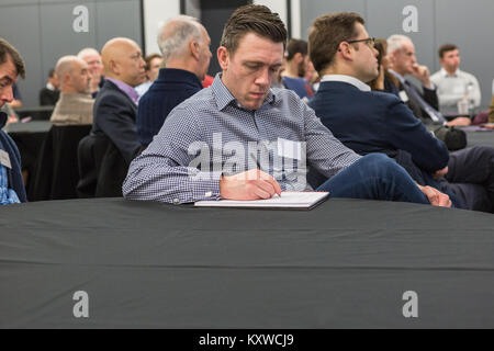 Businessman taking note with pen and paper during business seminar Stock Photo