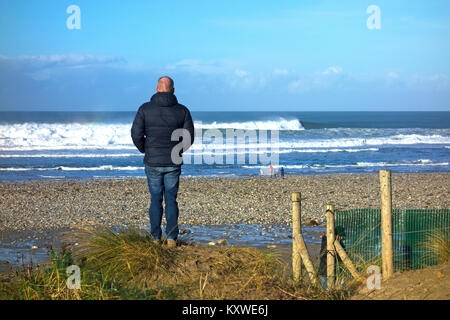 man alone looking out to sea at porthtowan, in cornwall, england, britain, uk. Stock Photo