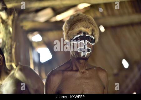 Portrait of a man from the tribe of Asmat people with ritual face painting on Asmat Welcoming ceremony. Stock Photo