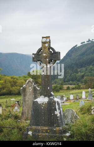 Old Irish Celtic Wheel Cross located at the graveyard on the ancient Monastic settlement site in the Glendalough Valley, county Wicklow, Ireland Stock Photo