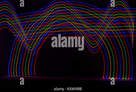 multi-coloured light trails patterns in the shape of waves and an arch - abstract painting with light, light painting Stock Photo