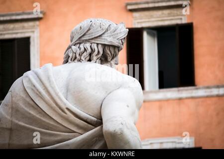 Statue of the god Zeus seen from behind, in the Fountain of the Four Rivers by Bernini in Piazza Navona, Rome - detail of the allegorical figures of t Stock Photo