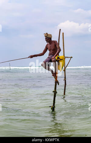 WELIGAMA, SRI LANKA - CIRCA DECEMBER 2013: Stilt fisherman Stock Photo