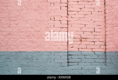 Pink and gray painted brick wall with a permanently closed door Stock Photo