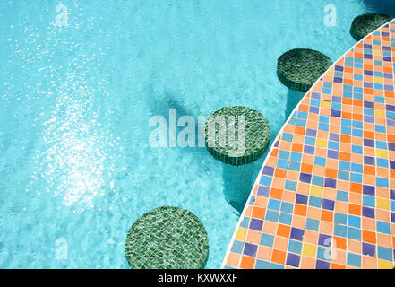 Colourful mosaic bar stools in a swimming pool Stock Photo