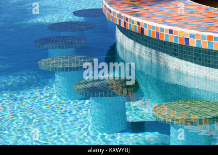 Colourful mosaic bar stools in a swimming pool Stock Photo