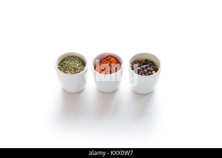 Close-up view of assorted aromatic dried spices in ceramic bowls isolated on white Stock Photo