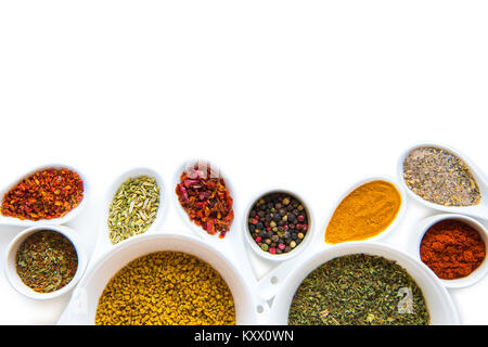 Top view of various dried aromatic spices in ceramic spoons and bowls isolated on white Stock Photo