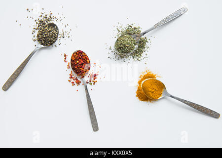 Top view of assorted aromatic spices in metal spoons isolated on white  Stock Photo