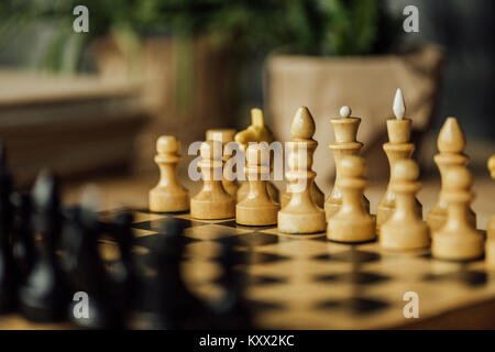 Old chess board set for a new game on the table. Selective focus on white chess pieces Stock Photo