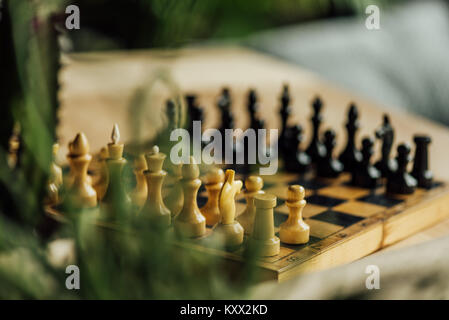 Old chess board set for a new game on the table. Selective focus on white chess pieces   Stock Photo