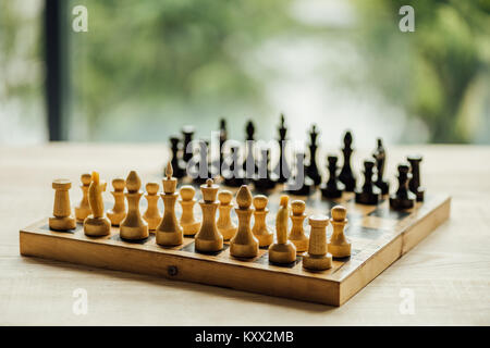 Old chess board set for a new game on the table. Selective focus on white chess figures  Stock Photo