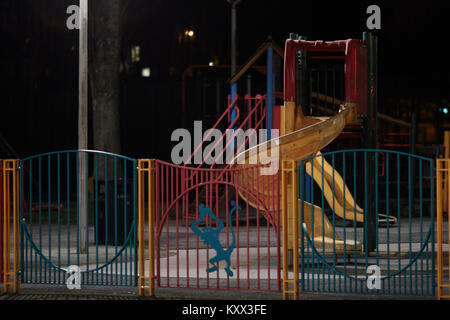 empty illuminated childrens slide in a playground at night Stock Photo