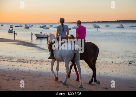 Evening horse riding along the beach at Sanlúcar de Barrameda, Spain Stock Photo