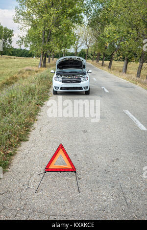 Closeup of red triangle to warn the other road users about a damaged car Stock Photo