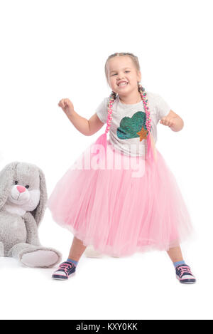 little girl posing together with big toys Stock Photo