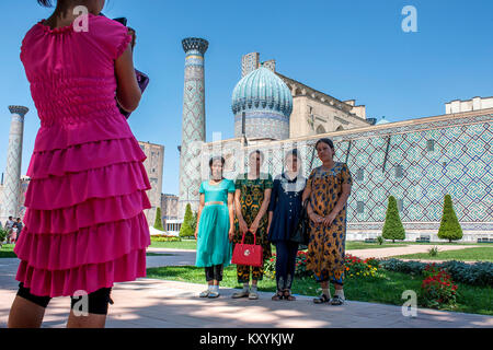 Women take pictures outside the Registan in Samarkand Stock Photo