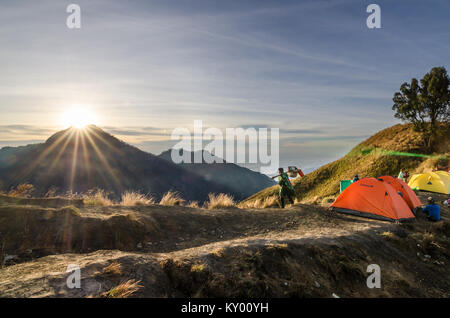 Porter of Mount. Rinjani helping hiker to carry stuff. The mountain is the second highest volcano in Indonesia and rises to 3,726 m Stock Photo