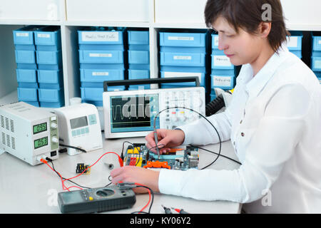 Tech tests electronic equipment in service centre Stock Photo