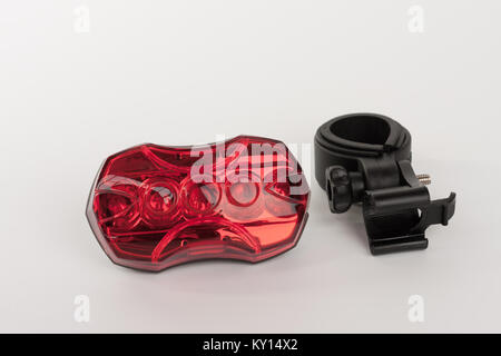 Red rear bicycle flashing light  and holder of light , studio photo, isolated on white background. Stock Photo