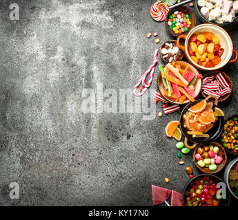 Multicolored candy, jelly and marshmallows in a bowl. On a rustic background. Stock Photo