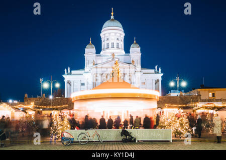 Helsinki, Finland. Xmas Christmas Market On Senate Square With Holiday Carousel And Famous Landmark Is Lutheran Cathedral In Winter Night. Stock Photo