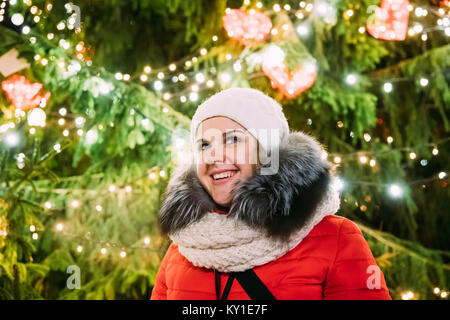 Tallinn, Estonia. Young Beautiful Pretty Caucasian Girl Woman Dressed In Red Jacket And White Hat Enjoying Life And Smiling On Background Christmas Tr Stock Photo
