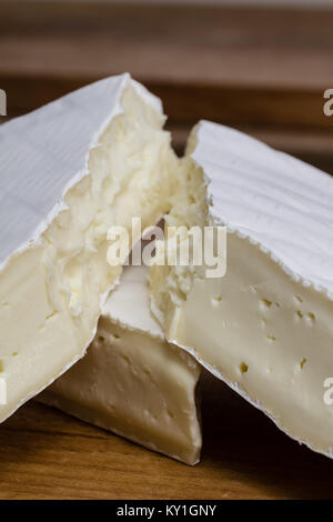Close up of Camembert cheese. Brie with coarse edge broken into pieces cremy and delicious. Stock Photo