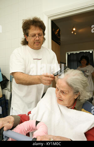 Live-in Health Care Managers give 24 hour support to elderly woman in wheelchair North London Stock Photo