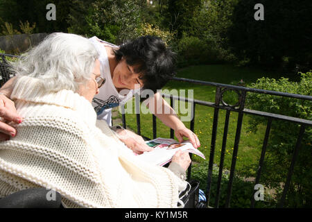 Live-in Health Care Managers give 24 hour support to elderly woman in wheelchair North London Stock Photo