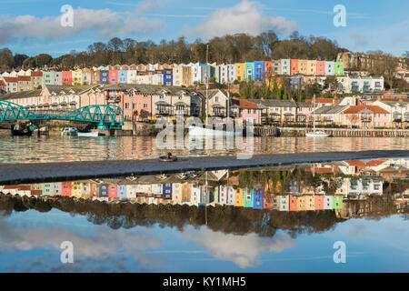 Colourful terraces of Cliftonwood in Bristol reflected in the waters of a puddle and those of the Floating Harbour, Bristol Stock Photo